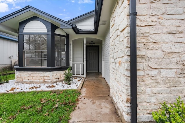 doorway to property with stone siding