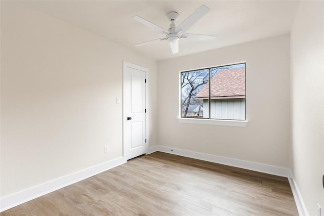 unfurnished room with baseboards, ceiling fan, and light wood-type flooring