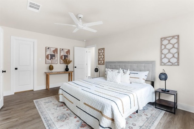 bedroom featuring baseboards, wood finished floors, and visible vents
