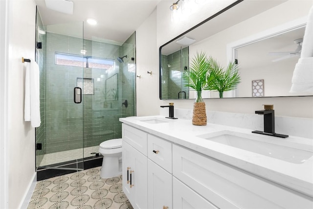 bathroom with double vanity, toilet, a shower stall, and a sink