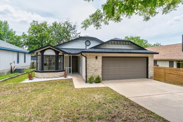 927 Peggotty Pl, Austin, TX 78753 - ranch-style house with an attached garage, stone siding, driveway, and roof with shingles