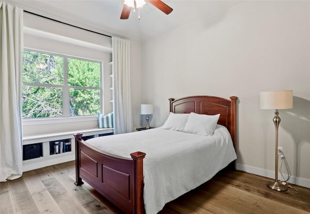 bedroom with light wood-type flooring, a ceiling fan, and baseboards