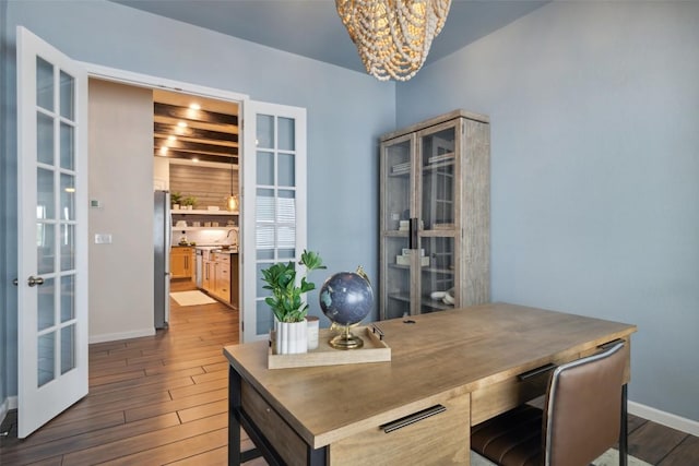16720 Horondelle Dr, Austin, TX 78738 - home office with french doors, a chandelier, wood finished floors, baseboards, and a sink