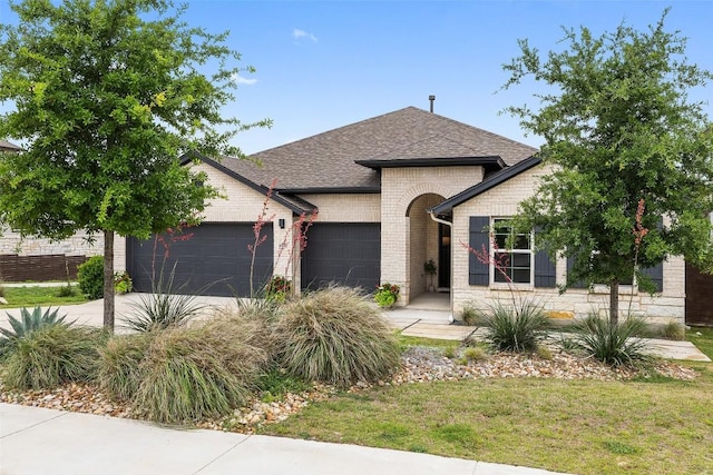 16720 Horondelle Dr, Austin, TX 78738 - view of front of home featuring a garage, driveway, brick siding, and a shingled roof