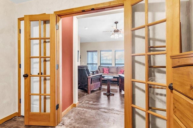 hallway with baseboards, concrete floors, and french doors