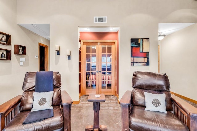 living area with baseboards, visible vents, and french doors