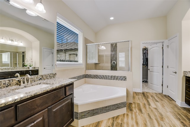full bath with vanity, a shower stall, a bath, and lofted ceiling