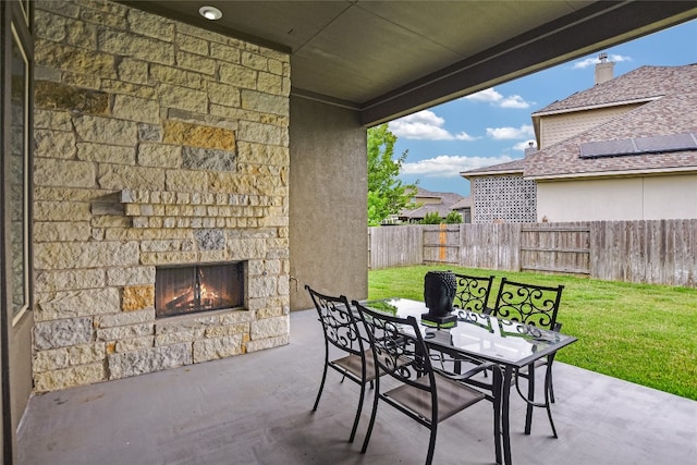 view of patio / terrace featuring an outdoor stone fireplace, fence, and outdoor dining space