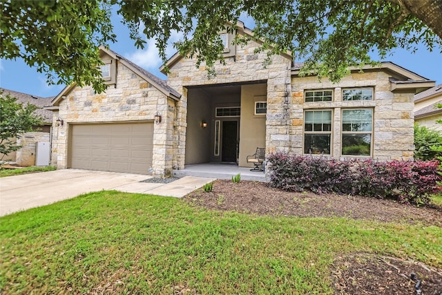 view of front of house with concrete driveway, an attached garage, stone siding, and a front lawn