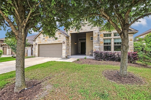 view of front of house featuring an attached garage, driveway, a front lawn, and stone siding
