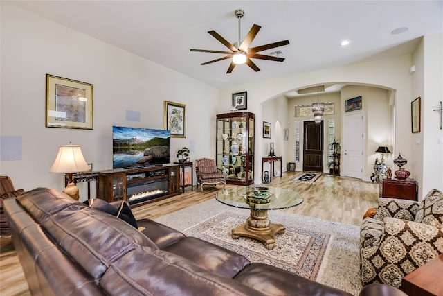 living area with arched walkways, a ceiling fan, recessed lighting, and wood finished floors