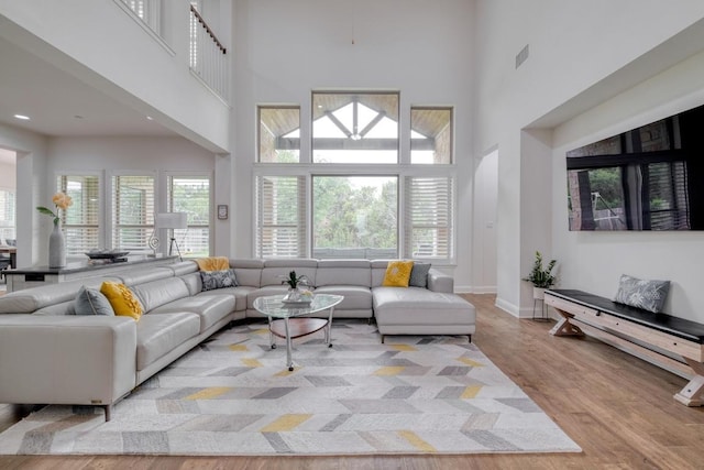 3908 Logan Ridge Dr, Cedar Park, TX 78613 - living area featuring a towering ceiling, wood finished floors, and baseboards