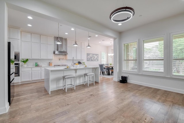 3908 Logan Ridge Dr, Cedar Park, TX 78613 - kitchen featuring healthy amount of natural light, wall chimney exhaust hood, oven, light countertops, and recessed lighting