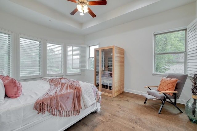 3908 Logan Ridge Dr, Cedar Park, TX 78613 - bedroom featuring baseboards, wood finished floors, a ceiling fan, and a tray ceiling