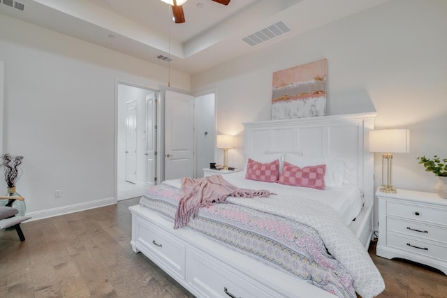 3908 Logan Ridge Dr, Cedar Park, TX 78613 - bedroom with dark wood-style floors, a raised ceiling, baseboards, and ensuite bathroom