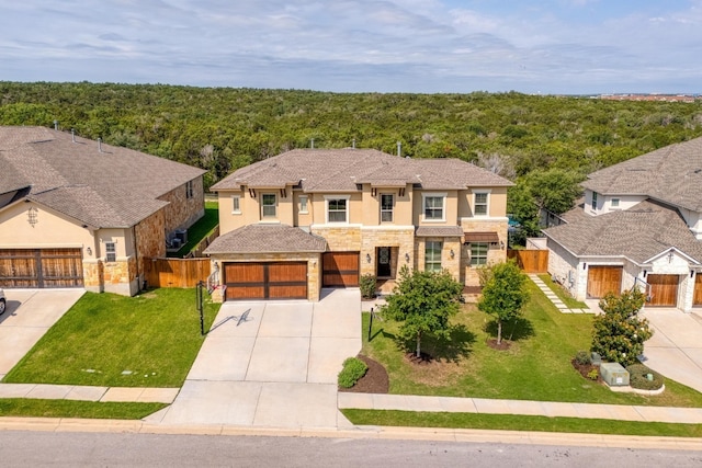 3908 Logan Ridge Dr, Cedar Park, TX 78613 - view of front of home with stone siding, stucco siding, concrete driveway, a forest view, and a garage
