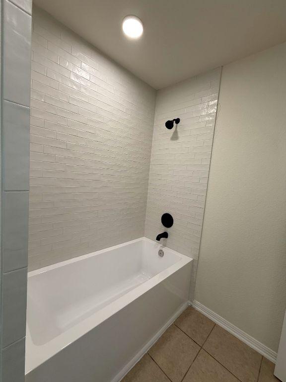 bathroom with shower / bathtub combination, tile patterned flooring, and baseboards