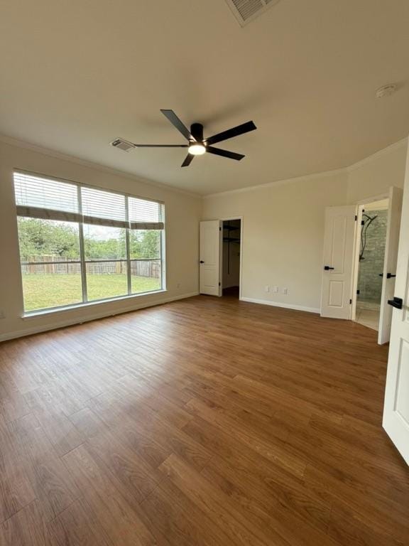 spare room featuring crown molding, a ceiling fan, wood finished floors, and visible vents
