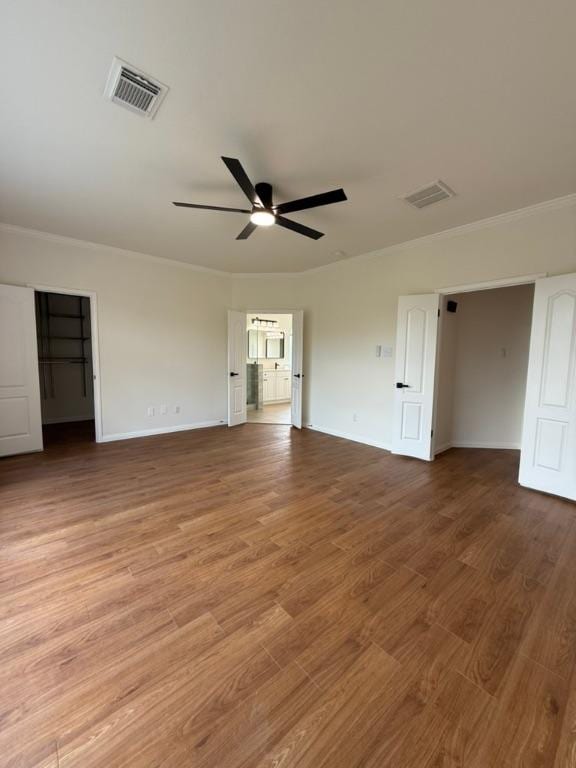 unfurnished bedroom with visible vents, ornamental molding, and baseboards