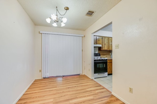 11948 Sunhillow Bnd Unit A & B, Austin, TX 78758 - unfurnished dining area with light wood finished floors, a chandelier, and a textured ceiling