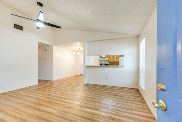11948 Sunhillow Bnd Unit A & B, Austin, TX 78758 - unfurnished living room with a textured ceiling, visible vents, lofted ceiling, and light wood-style floors