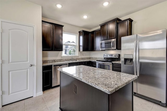 1139 Amy Dr, Kyle, TX 78640 - kitchen with a kitchen island, dark brown cabinets, light stone countertops, and appliances with stainless steel finishes