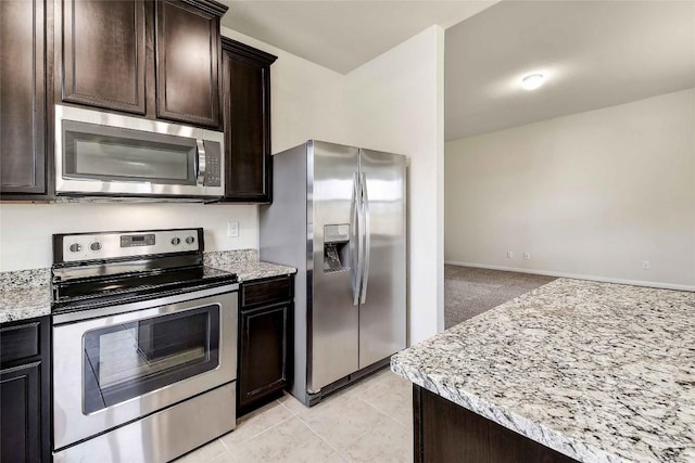 1139 Amy Dr, Kyle, TX 78640 - kitchen with appliances with stainless steel finishes, dark brown cabinets, and light stone countertops