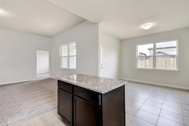 1139 Amy Dr, Kyle, TX 78640 - kitchen featuring baseboards, open floor plan, a center island, light stone counters, and light tile patterned floors