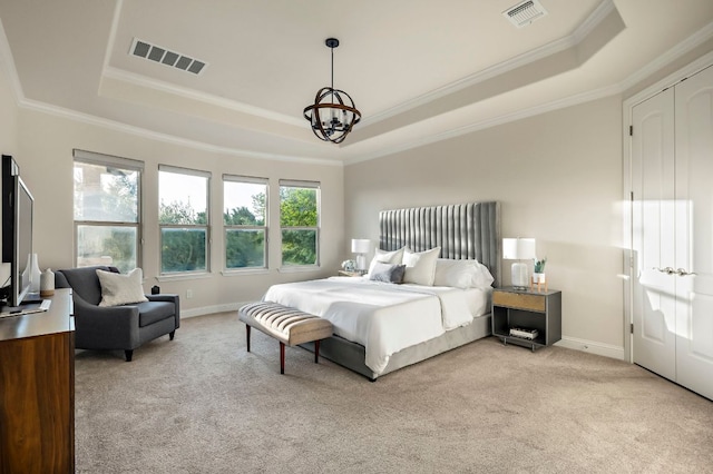bedroom with ornamental molding, light carpet, a tray ceiling, and visible vents