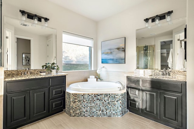full bathroom with a sink, a bath, a stall shower, and two vanities