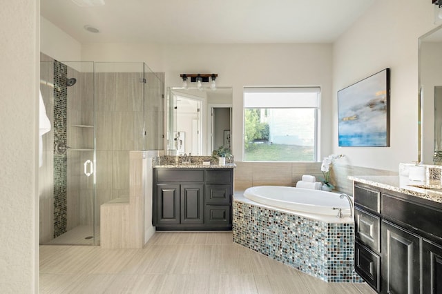 bathroom featuring tile patterned floors, a sink, a garden tub, and a stall shower