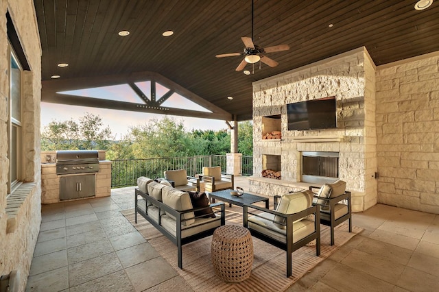view of patio with a ceiling fan, an outdoor living space with a fireplace, and a grill