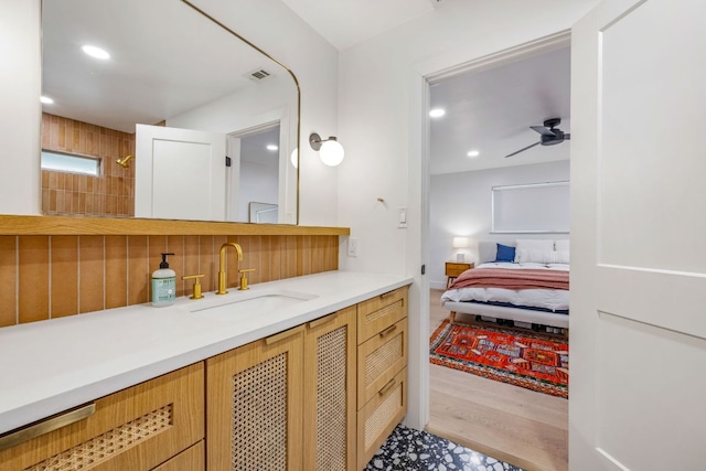 ensuite bathroom with backsplash, recessed lighting, a ceiling fan, and wood finished floors