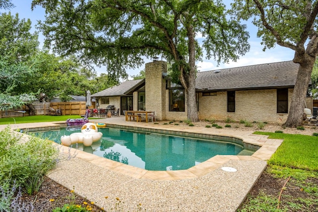 view of pool with a patio, fence, a yard, and a fenced in pool