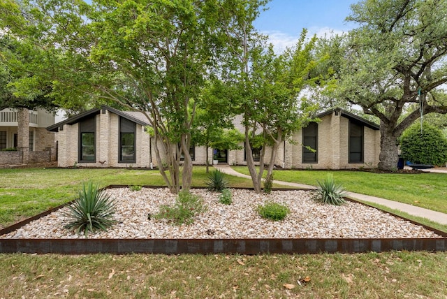 view of front of house featuring brick siding and a front lawn
