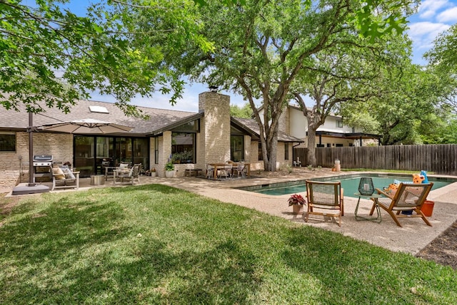 view of swimming pool featuring a fenced in pool, a fenced backyard, a yard, and a patio
