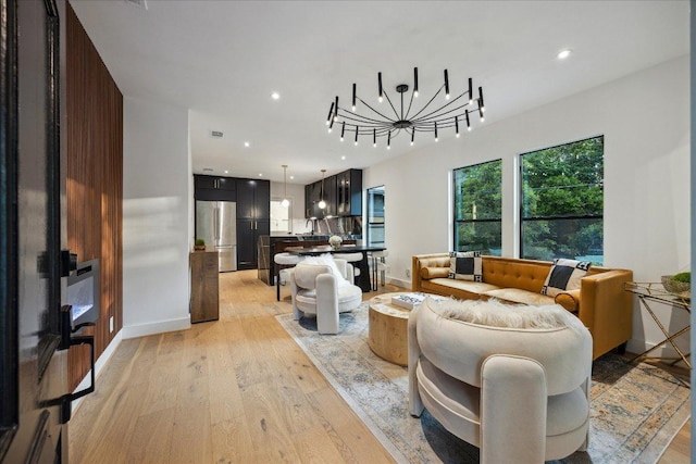 living room featuring recessed lighting, light wood finished floors, and baseboards