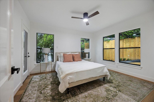 bedroom with baseboards, ceiling fan, and wood finished floors
