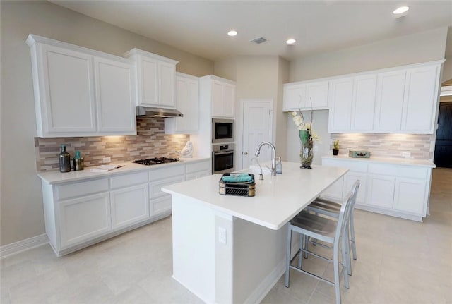 148 Golden Sage Ave, Georgetown, TX 78633 - kitchen with oven, built in microwave, decorative backsplash, a kitchen island with sink, and white cabinets