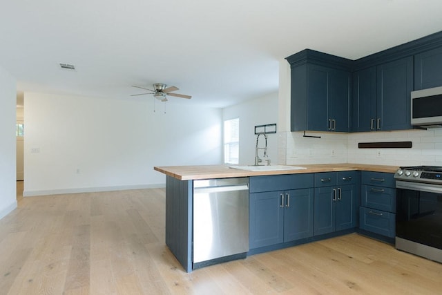 5711 Steven Creek Way, Austin, TX 78721 - kitchen with ceiling fan, visible vents, appliances with stainless steel finishes, a sink, and wood counters