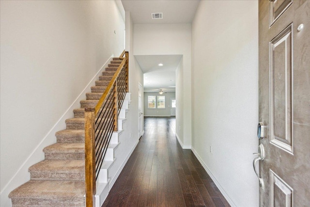 entrance foyer with a ceiling fan, visible vents, dark wood finished floors, stairway, and baseboards