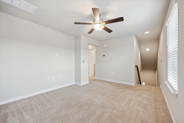 empty room featuring visible vents, baseboards, ceiling fan, and light colored carpet