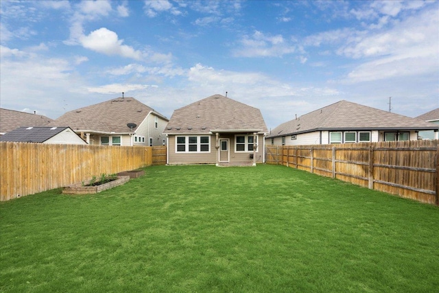 back of house featuring a lawn and a fenced backyard