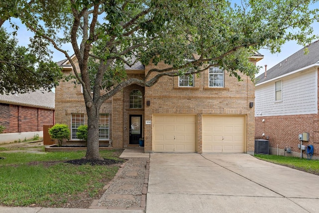 traditional home with brick siding, driveway, a front yard, and a garage