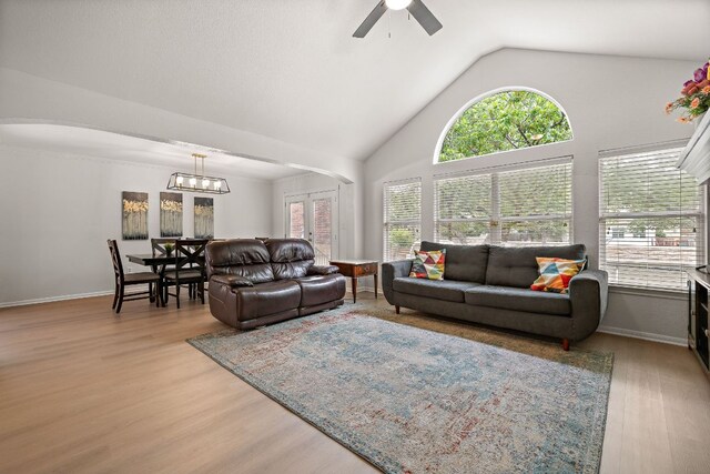 2104 Faldo Ln, Round Rock, TX 78664 - living room with ceiling fan, light wood finished floors, a chandelier, baseboards, and high vaulted ceiling