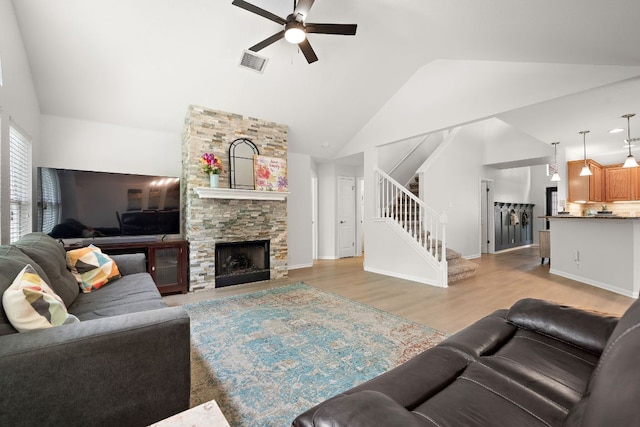 2104 Faldo Ln, Round Rock, TX 78664 - living area with a ceiling fan, stairs, lofted ceiling, light wood-type flooring, and a stone fireplace
