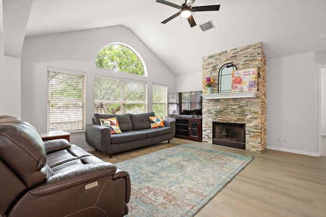 2104 Faldo Ln, Round Rock, TX 78664 - living area featuring ceiling fan, wood finished floors, a stone fireplace, high vaulted ceiling, and baseboards