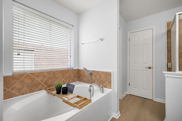 2104 Faldo Ln, Round Rock, TX 78664 - bathroom featuring a garden tub and wood finished floors