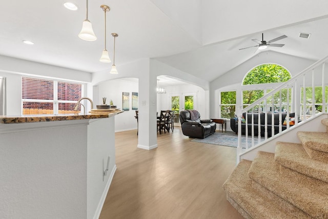 2104 Faldo Ln, Round Rock, TX 78664 - living room featuring arched walkways, light wood-style flooring, a ceiling fan, lofted ceiling, and stairs