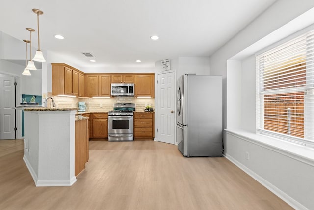 2104 Faldo Ln, Round Rock, TX 78664 - kitchen featuring stainless steel appliances, light wood-style flooring, decorative backsplash, light stone countertops, and recessed lighting